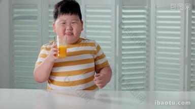 <strong>快乐</strong>的小胖男孩喝橙汁